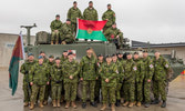 Strathconas demonstrating their comfort crawling on top of armoured vehicles for a group photo
