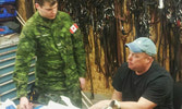 Saddlemaker Glen Olund shows Cpl Morgan the ins and outs of the steel arch saddles created for SMT